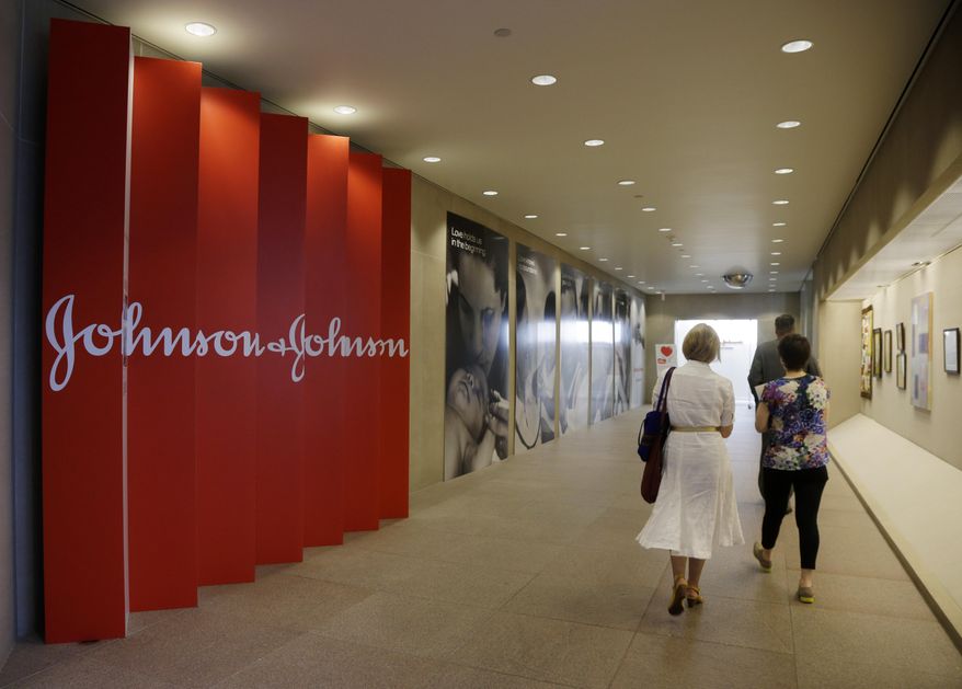 FILE - In this Tuesday, July 30, 2013, file photo, people walk along a corridor at the headquarters of Johnson & Johnson in New Brunswick, N.J. Johnson & Johnson on Wednesday, May 20, 2015 said it is predicting big returns from its prescription drug business, both financially and medically, as it develops treatments and strategies to intervene earlier and prevent or reduce the damage from several conditions, including Alzheimer's disease and diabetes. (AP Photo/Mel Evans, File)