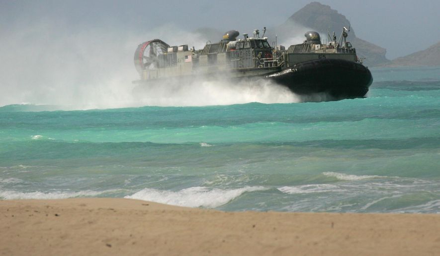 A U.S. Navy Landing Craft Air Cushion (LCAC) amphibious vehicle rushes the beach at Bellows Air Force Station on Oahu, Hawaii during joint amphibious exercises, as the U.S. Marine Corps and Navy host defense leaders from around the Pacific, Tuesday, May 19, 2015. The first-of-its kind meeting comes as territorial disputes over islands are growing more heated in the region. (AP Photo/Caleb Jones)