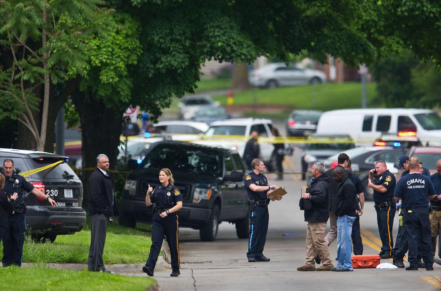 Law enforcement officers gather near the scene of a shooting Wednesday, May 20, 2015 in Omaha, Neb. Police say one female officer and at least one other person were shot and are being treated at an Omaha hospital. (Chris Machian/Omaha World-Herald via AP) MAGS OUT TV OUT
