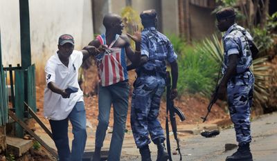 Police and a member of the Intelligence Services in civilian clothes detain a protester in the Nyakabyga neighborhood of Bujumbura, Burundi. Police fired live rounds and tear gas to disperse demonstrators protesting the president&#x27;s seeking a third term. (associated press)