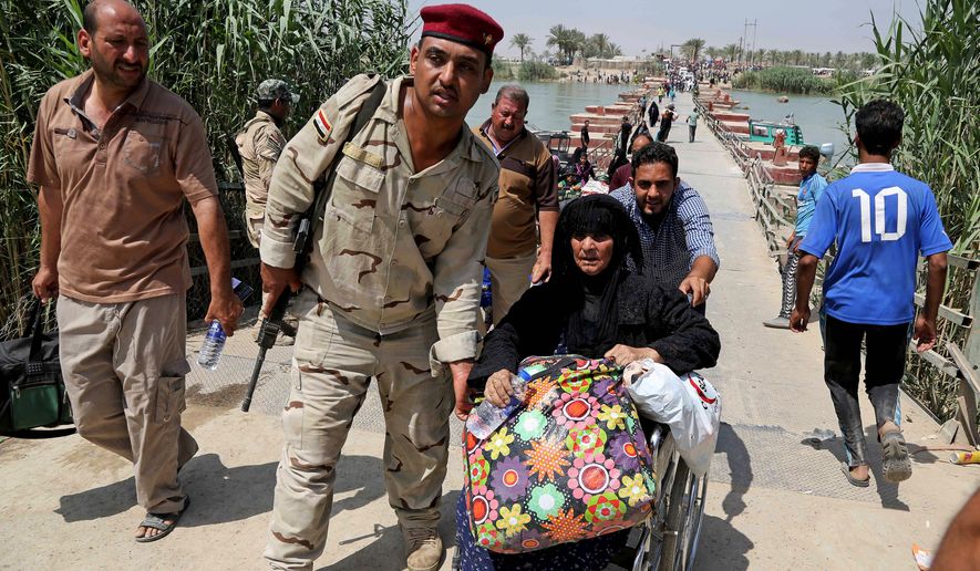 An Iraqi soldier helped one of thousands of Ramadi residents leave Wednesday after the city was seized by Islamic State fighters. Former trainers say Iraqi troops are in dire need of unity and leadership in government. (Associated Press)