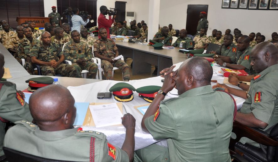 FILE - In this Wednesday Oct. 15, 2014 file photo, soldiers accused of refusing to fight in the country's northeastern Islamic uprising appear before a court martial in Abuja, Nigeria. Nearly 600 Nigerian officers and troops faced charges before a court-martial Wednesday May 20, 2015, the army said of an unprecedented number of soldiers believed to be on trial for alleged offenses related to the ongoing fight against an Islamic uprising in the northeast. (AP Photo/Olamikan Gbemiga, File)