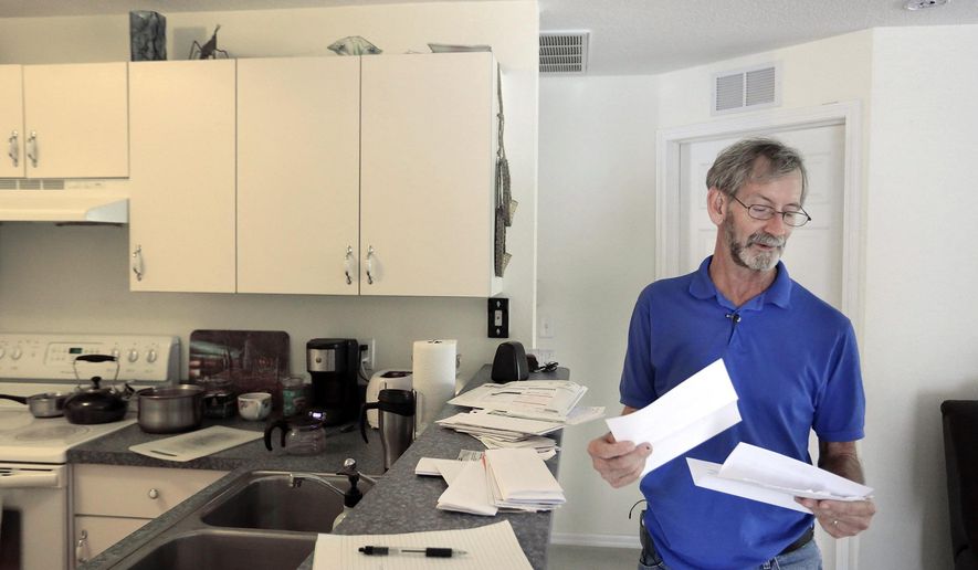 Doug Hughes reads some of the letters of support that he has received since he landed his gyrocopter on the west lawn of the US Capital last month. On Tuesday, May 19, 2015, Hughes will drive up to Washington D.C. for his first preliminary hearing later in the week. (James Borchuck/The Tampa Bay Times via AP)