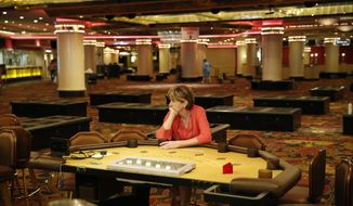 A woman who declined to give her name, sits at a table in the casino during a liquidation sale at the closed Riviera Hotel and Casino Thursday, May 14, 2015, in Las Vegas. The Riviera Hotel and Casino closed May 4, but everything inside the 2,075-room hotel-casino must go. National Content Liquidators has started selling it all at a public sale that started 9 a.m. Thursday.  (AP Photo/John Locher)