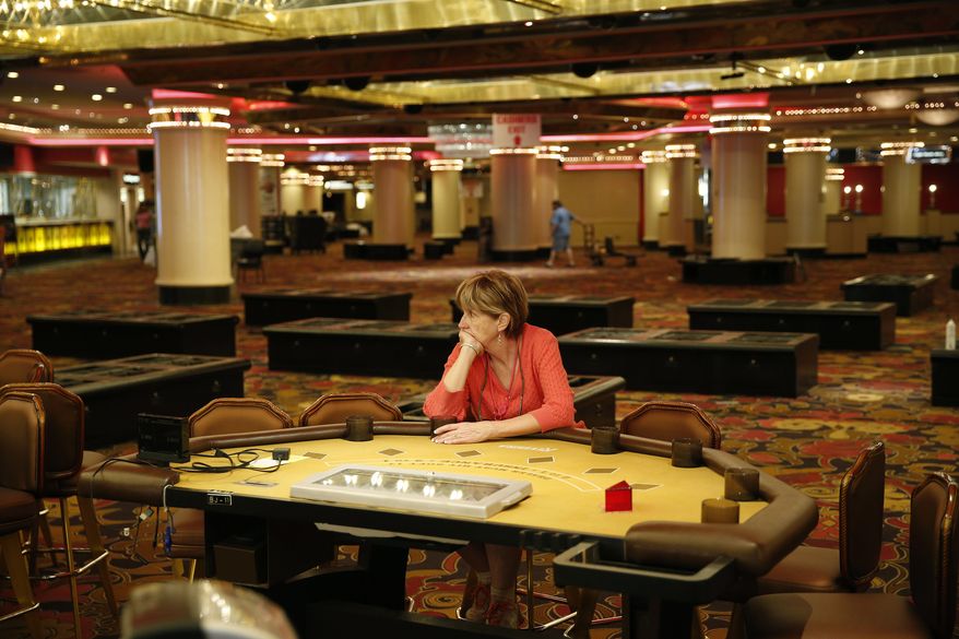 A woman who declined to give her name, sits at a table in the casino during a liquidation sale at the closed Riviera Hotel and Casino Thursday, May 14, 2015, in Las Vegas. The Riviera Hotel and Casino closed May 4, but everything inside the 2,075-room hotel-casino must go. National Content Liquidators has started selling it all at a public sale that started 9 a.m. Thursday.  (AP Photo/John Locher)