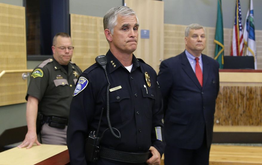 Olympia Police Chief Ronnie Roberts, center, stands with prosecutor Jon Tunheim, right, and Thurston County Sheriff's Office Chief Deputy Brad Watkins, left, as they wait to talk to reporters, Thursday, May 21, 2015, in Olympia, Wash. Two stepbrothers suspected of trying to steal beer from the store were shot early Thursday in Olympia by a police officer who confronted them nearby and reported he was being assaulted with a skateboard. The stepbrothers are expected to survive. (AP Photo/Ted S. Warren)
