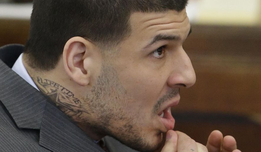 Sporting a new neck tattoo former New England Patriots NFL football player Aaron Hernandez sits at the defense table during his arraignment on a charge of trying to silence a witness in a double murder case against him by shooting the man in the face at Suffolk Superior Court, Thursday, May 21, 2015, in Boston. Hernandez was convicted last month in the 2013 murder of Odin Lloyd. (AP Photo/Stephan Savoia, Pool)