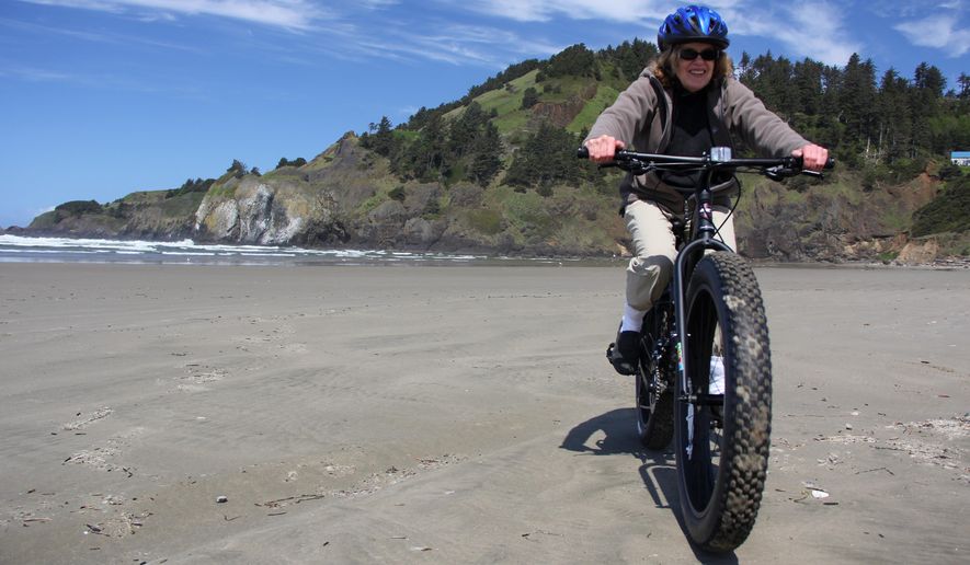 In this April 29, 2015 photo, Deborah Achor, 65, of Minnesota, fat bikes the Nye Beach area on the Oregon Coast. Owners of Bike Newport, one of the few businesses to rent fat bikes on the coast,said that they have seen an increase in rentals this year and are hoping it will continue to grow. (Zach Urness/Statesman-Journal via AP)