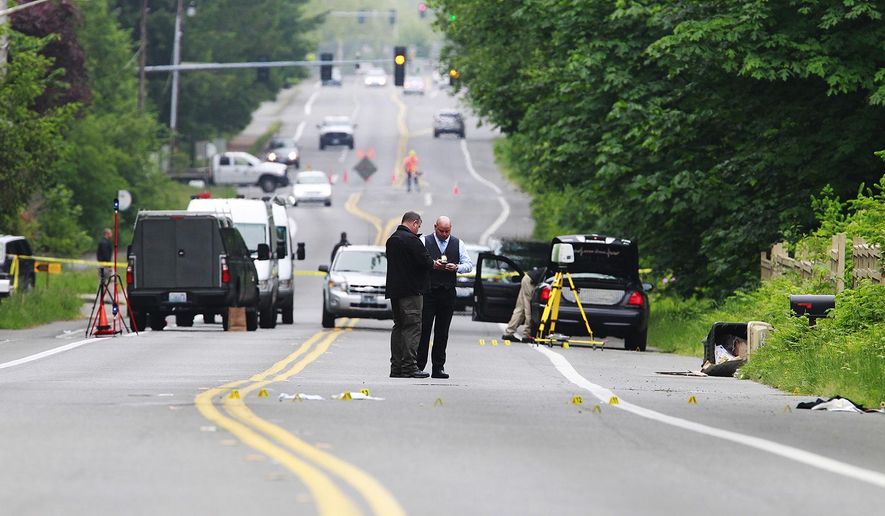 Investigators comb the scene of an officer-involved shooting Thursday, May 21, 2015 in Olympia,Wash. Police in the capital of Washington state say an officer shot two men in their 20s suspected of trying to steal beer from a grocery store. (Steve Bloom/The Olympian via AP)