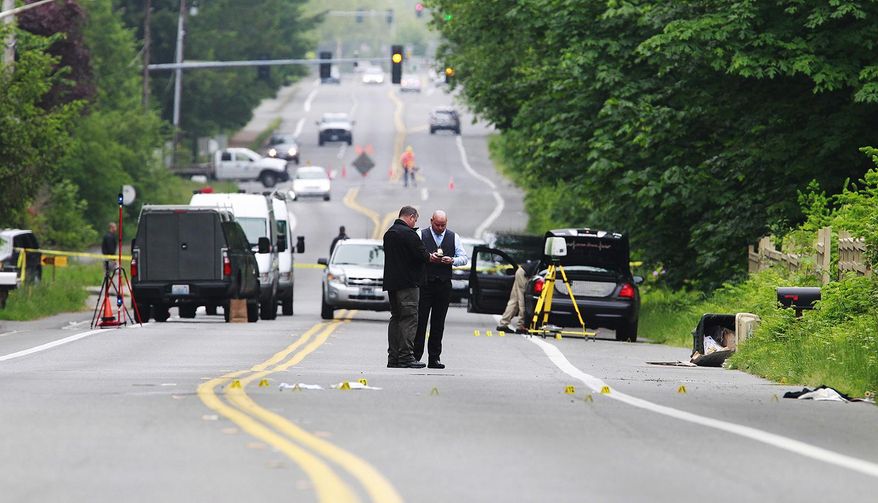 Investigators comb the scene of an officer-involved shooting Thursday, May 21, 2015 in Olympia,Wash. Police in the capital of Washington state say an officer shot two men in their 20s suspected of trying to steal beer from a grocery store. (Steve Bloom/The Olympian via AP)