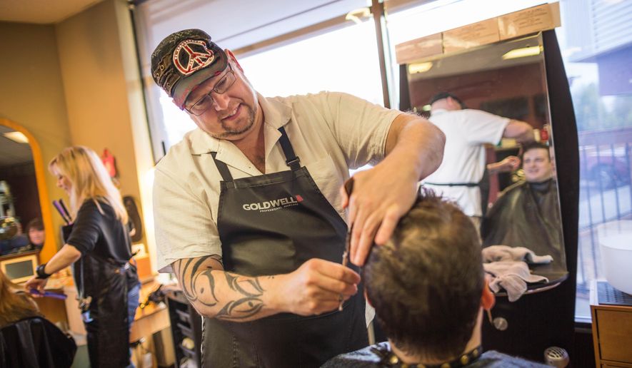 ADVANCE FOR SATURDAY, MAY 23 AND THEREAFTER - Hairdresser Joseph Williams gives Scott Stroman a free haircut at Salon Avi on Friday, May 15, 2015 in Anchorage, Alaska. Williams offers free haircuts to people in need. He lives by the philosophy that the energy one puts out will come back around, be it positive or negative. His business is “Karma Cuts,” and he says his offer is meant to send positivity out into the world. (Lowen Holmes/Alaska Dispatch News via AP)