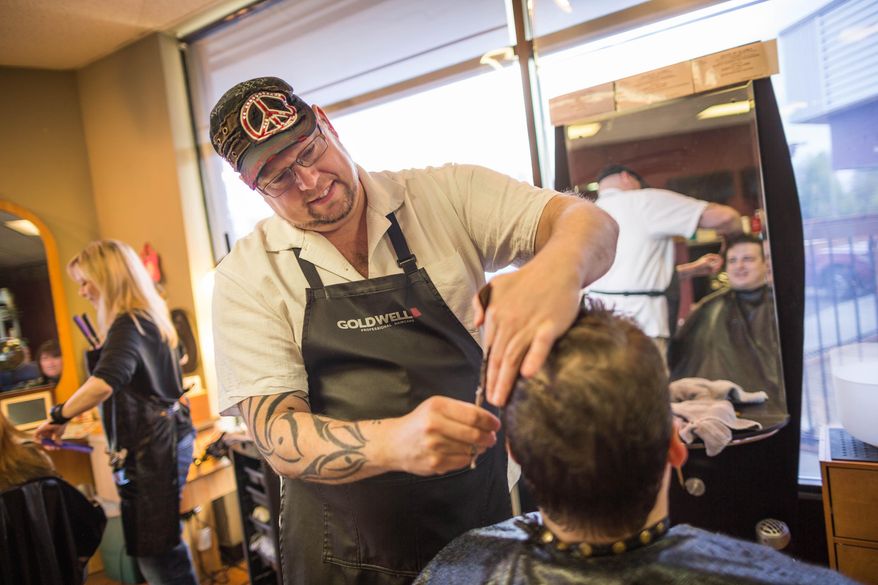 ADVANCE FOR SATURDAY, MAY 23 AND THEREAFTER - Hairdresser Joseph Williams gives Scott Stroman a free haircut at Salon Avi on Friday, May 15, 2015 in Anchorage, Alaska. Williams offers free haircuts to people in need. He lives by the philosophy that the energy one puts out will come back around, be it positive or negative. His business is “Karma Cuts,” and he says his offer is meant to send positivity out into the world. (Lowen Holmes/Alaska Dispatch News via AP)