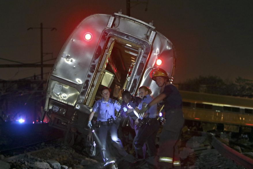 FILE - In this May 12, 2015 file photo, emergency personnel work the scene of a deadly train wreck in Philadelphia. An Amtrak train headed to New York City derailed and crashed in Philadelphia. Senate Democrats are demanding more money for Amtrak so the railroad can tackle a $21 billion backlog in repair and replacement projects. They say that backlog compromises safety and service.(AP Photo/ Joseph Kaczmarek)