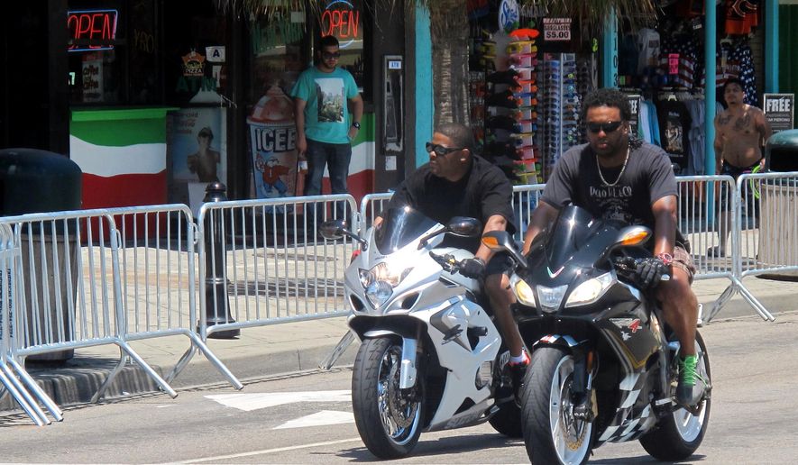 In this photo taken Tuesday, May 19, 2015, motorcyclists ride through Myrtle Beach, S.C. Tens of thousands of bilkers are expected in the area this Memorial Day weekend for the annual Atlantic Beach Bikefest that begins in the predominantly black hamlet of Atlantic Beach on Friday, May 22. After violence in nearby communities left three dead last year, visitors will be greeted with increased security measures. (AP Photo/Bruce Smith)