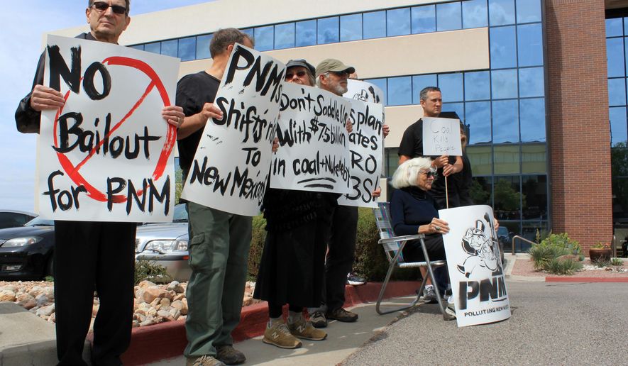 Verne Loose, left, joins a group of protesters concerned about a plan by Public Service Co. of New Mexico to shut down part of the coal-fired San Juan Generating Station during a rally in Albuquerque N.M., on Thursday, May 21, 2015. The protest came as business leaders were meeting to share their support for PNM's plan. (AP Photo/Susan Montoya Bryan)