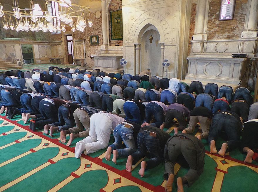 In this picture taken on May 15, 2015 and made available on Friday, May 22, 2015, Muslims pray inside the former Misericordia Abbey in Venice, Italy. Venice officials have ordered the closure of a working mosque set up as Iceland's exhibit for the 56th Venice Biennale contemporary art fair in what was once a Catholic church. (AP Photo/Luigi Costantini)