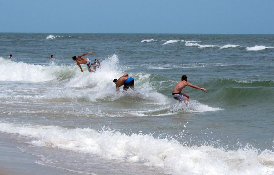 This June 30, 2014 photo, surfers ride waves in Ship Bottom, N.J. on Long Beach Island. Two New Jersey lawmakers on Friday May 22, 2015 called on Rutgers University to cancel planned ocean blasting tests off Long Beach island that they say will harm marine life and threaten new Jersey's crucial tourism industry. (AP Photo/Wayne Parry)