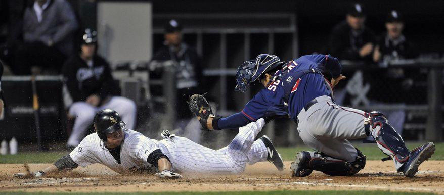 Chicago White Sox&#39;s J.B. Shuck (20), slides into home plate safely as Minnesota Twins catcher Kurt Suzuki (8), tries to apply the tag after Chicago White Sox&#39;s Geovany Soto hit a 2 RBI double during the fourth inning of a baseball game in Chicago, Friday, May 22, 2015. (AP Photo/Paul Beaty)