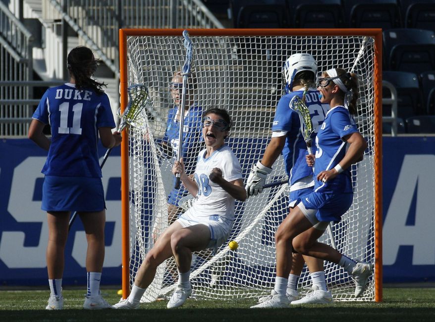 North Carolina&#39;s defender Courtney Waite, center, reacts to her goal on Duke&#39;s goalie Kelsey Duryea, center right, during the first half of the semifinals in the NCAA Division I women&#39;s lacrosse tournament, Friday, May 22, 2015, in Chester, Pa. (AP Photo/Chris Szagola)