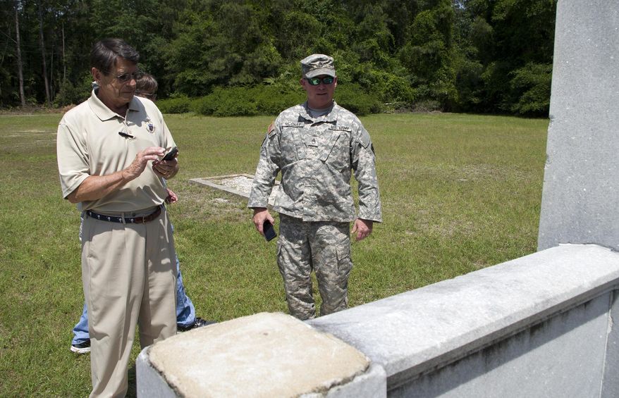 Barry Wingard, left, and Sgt. Ricky McCary of the South Carolina Army National Guard survey the WWI monument behind American Legion Post 1 on May 12, 2015 in Florence, S.C. McCary's guard unit will be lending its heavy lift capabilities toward relocating the monument to the Florence Veterans Park at the Florence Civic Center. (Matthew Robertson /The Morning News via AP) LOCAL TELEVISION OUT; MANDATORY CREDIT; NO SALES