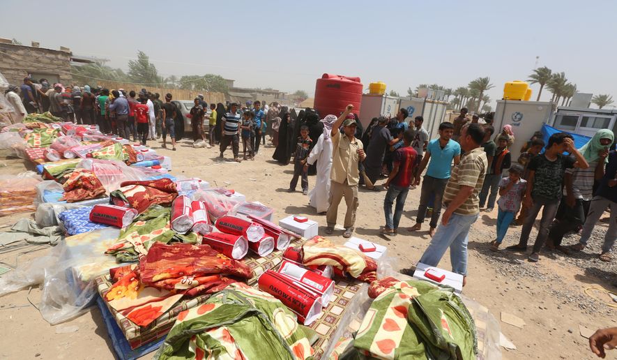 Displaced civilians from Ramadi wait to receive humanitarian aid from the United Nations in a camp in the town of Amiriyat al-Fallujah, west of Baghdad, Iraq, Friday, May 22, 2015. The United Nations World Food Program said it is rushing food assistance into Anbar to help tens of thousands of residents who have fled Ramadi after it was taken by Islamic State militant group. (AP Photo/Hadi Mizban)