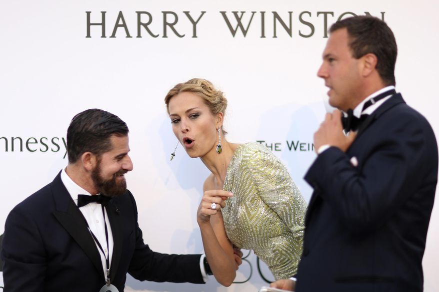 Model Petra Nemcova, center, and unidentified guests arrive for the amfAR Cinema Against AIDS benefit at the Hotel du Cap-Eden-Roc, during the 68th Cannes international film festival, Cap d'Antibes, southern France, Thursday, May 21, 2015. (AP Photo/Thibault Camus)