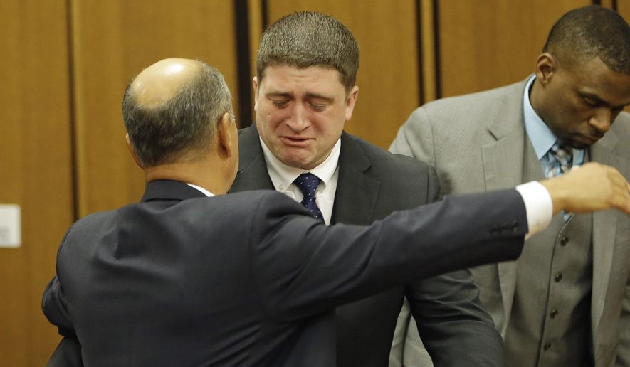 Michael Brelo hugs his attorney, Patrick D’Angelo, after the verdict in his trial Saturday, May 23, 2015, in Cleveland. Brelo, a patrolman charged in the shooting deaths of two unarmed suspects during a 137-shot barrage of gunfire was acquitted Saturday in a case that helped prompt the U.S. Department of Justice determine the city police department had a history of using excessive force and violating civil rights. (AP Photo/Tony Dejak)