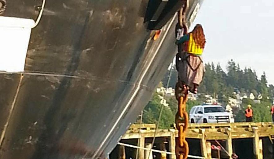In this Friday, May 22, 2015 photo provided by Reese Semanko, a woman identified as Chiara Rose has suspended herself in a climbing harness from the anchor chain of the Royal Dutch Shell support ship Arctic Challenger in the harbor at Bellingham, Wash. Rob Lewis, spokesman for protest organizers Rising Tide Bellingham, said Lewis said she is protesting Shell's plan for Arctic drilling. The Coast Guard says it has no plans to remove her but has impounded the activists' support vessels. The ship isn't scheduled to leave the port for several days.(Reese Semanko via AP)