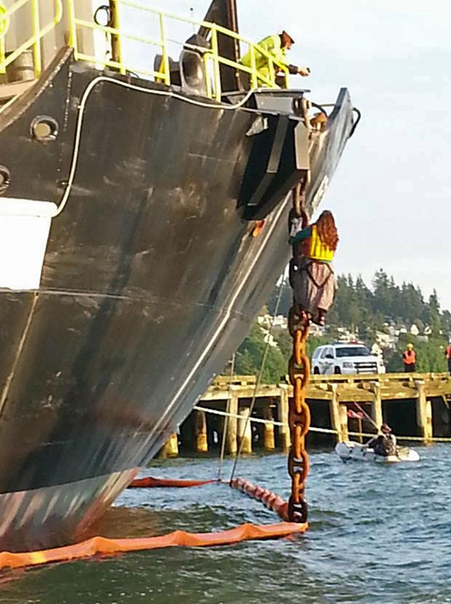 In this Friday, May 22, 2015 photo provided by Reese Semanko, a woman identified as Chiara Rose has suspended herself in a climbing harness from the anchor chain of the Royal Dutch Shell support ship Arctic Challenger in the harbor at Bellingham, Wash. Rob Lewis, spokesman for protest organizers Rising Tide Bellingham, said Lewis said she is protesting Shell's plan for Arctic drilling. The Coast Guard says it has no plans to remove her but has impounded the activists' support vessels. The ship isn't scheduled to leave the port for several days.(Reese Semanko via AP)