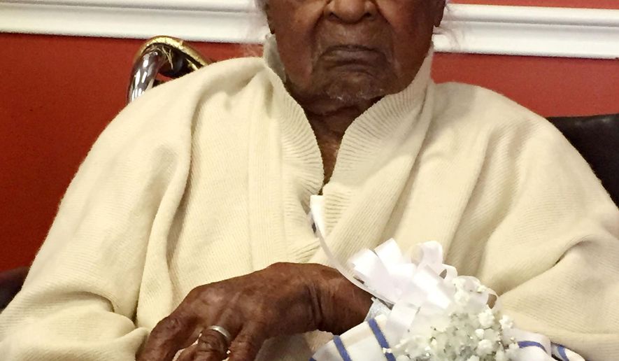 In this Thursday, May 21, 2015 photo, Jeralean Talley, born on May 23, 1899, is honored at the Inkster, Mich. district office of the Michigan Department of Health and Human Services. On Saturday, May 23, 2015, she plans to celebrate her 116th birthday. Talley bowled until she was 104 and still likes to catch fish. (Elisha Anderson/Detroit Free Press via AP)