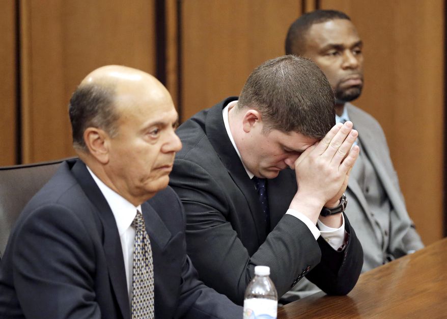 Michael Brelo, center, listens to the judge reading his verdict during his trial Saturday, May 23, 2015, in Cleveland. (AP Photo/Tony Dejak)