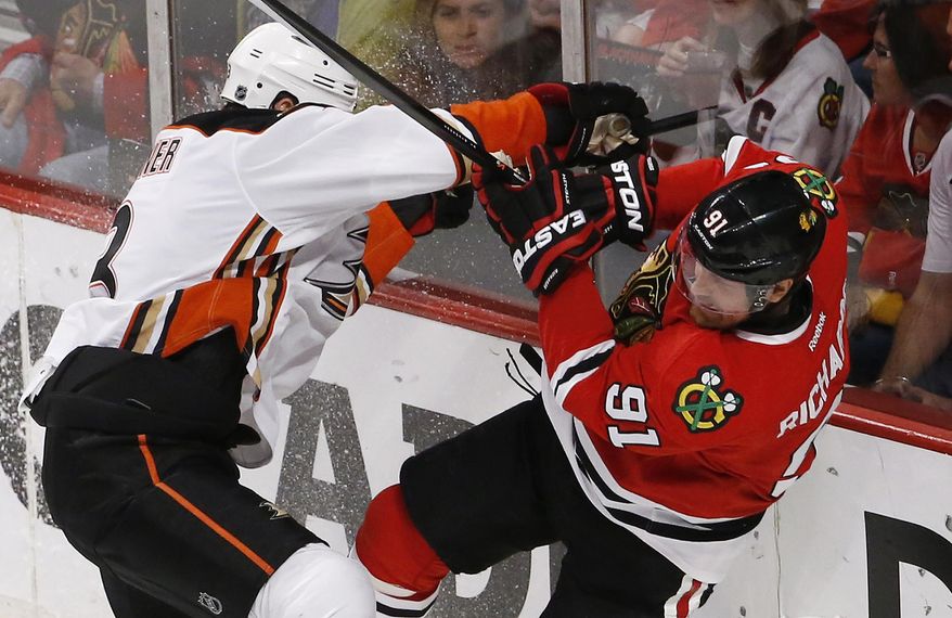 Anaheim Ducks defenseman Clayton Stoner, left, checks Chicago Blackhawks center Brad Richards (91) during the second period in Game 4 of the Western Conference finals of the NHL hockey Stanley Cup playoffs, Saturday, May 23, 2015, in Chicago. (AP Photo/Charles Rex Arbogast)