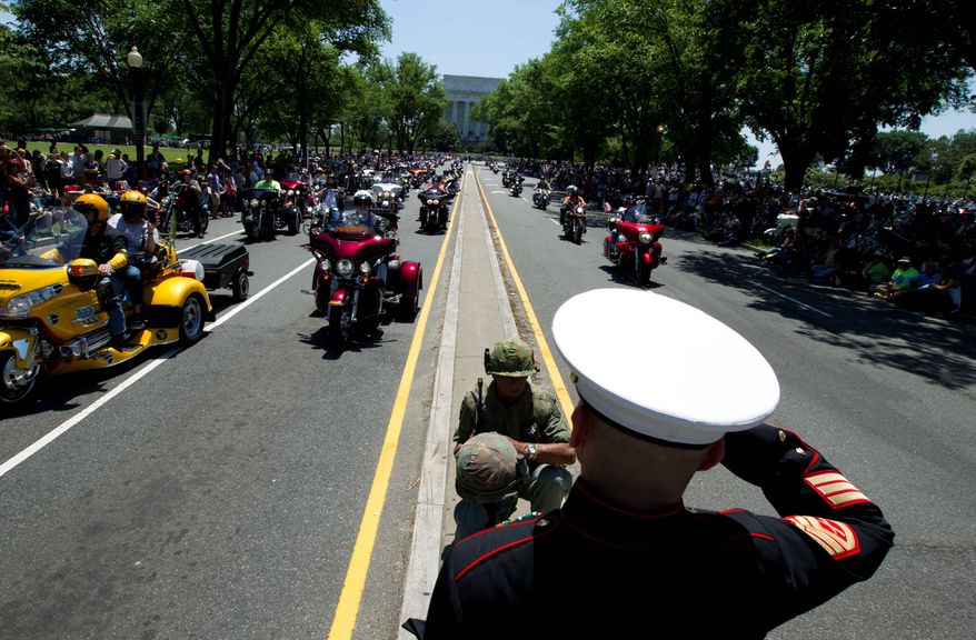 Looking ahead: Marine Tim Chamber and Army veteran Eric Cantu saluted during the Rolling Thunder Ride for Freedom on Sunday. Although the event has grown, the number of riders who fought in Vietnam is dwindling. (Associated Press)