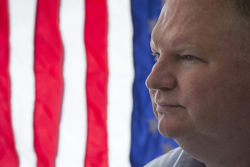 Army veteran Jim Farrell, owner of Lawson Flag Supply Co., stands at the register of his business, Friday, May 22, 2015, in Columbus, Ohio. New legislation introduced in Ohio state’s House Ways and Means Committee aims to assist veteran entrepreneurs by providing a 5 percent or $5,000 bid preference to their businesses when competing for state contracts. A joint sponsor of the bill says there is a moral obligation to help those who served their country. (AP Photo/John Minchillo)