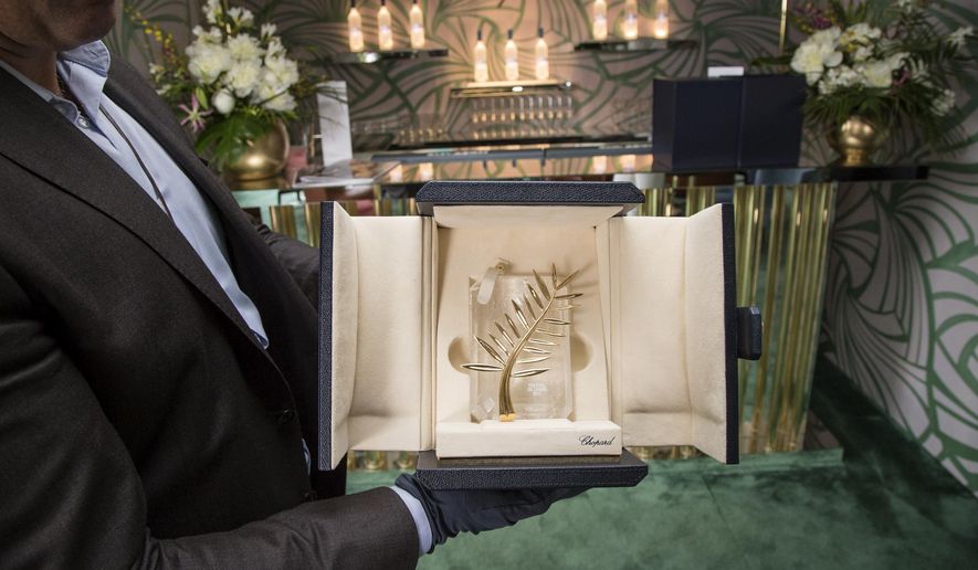 A person poses for a photograph with a box containing the Palme d'Or award, which will be presented on Sunday, at the 68th international film festival, Cannes, southern France, Saturday, May 23, 2015. (Photo by Vianney Le Caer/Invision/AP)