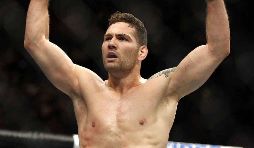 Chris Weidman celebrates after defeating Vitor Belfort in their middleweight mixed martial arts bout at UFC 187 Saturday, May 23, 2015, in Las Vegas. (AP Photo/John Locher)