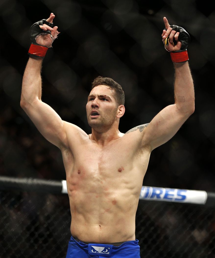 Chris Weidman celebrates after defeating Vitor Belfort in their middleweight mixed martial arts bout at UFC 187 Saturday, May 23, 2015, in Las Vegas. (AP Photo/John Locher)