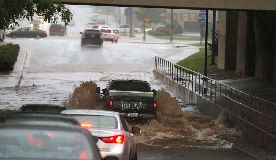 A vehicle tries to cross flood waters in Oklahoma City after storms brought heavy rain Saturday, May 23, 2015. The Oklahoma Department of Transportation said at least 15 highways have been closed across the state due to high water from the recent flooding. (Sarah Phipps/The Oklahoman via AP) LOCAL STATIONS OUT (KFOR, KOCO, KWTV, KOKH, KAUT OUT); LOCAL WEBSITES OUT; LOCAL PRINT OUT (EDMOND SUN OUT, OKLAHOMA GAZETTE OUT) TABLOIDS OUT