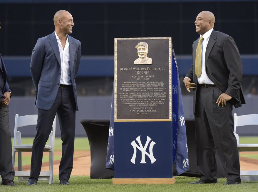 Former New York Yankees Bernie Williams, right, and Derek Jeter react as they stand by a replica of Williams&#39; plaque, which will be displayed in Monument Park, before a baseball game against the Texas Rangers Sunday, May 24, 2015, at Yankee Stadium in New York. (AP Photo/Bill Kostroun)