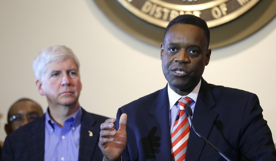 FILE - In this Nov. 7, 2014, file photo, Michigan Gov. Rick Snyder, left, listens as Detroit emergency manager Kevyn Orr address the media during a news conference in Detroit. Orr, Snyder and presidential historian Doris Kearns Goodwin are among the speakers as Michigan’s business elite gather on Mackinac Island for three days beginning Wednesday, May 27, 2015, for the Detroit Regional Chamber's annual policy conference. (AP Photo/Carlos Osorio, File)