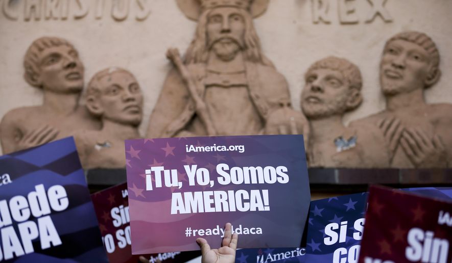 A woman holds a sign that says in Spanish, &quot;you, me, we are America!&quot; during a rally in support of President Obama&#39;s plan to protect more than 4 million people living illegally in the U.S. from deportation in front of a church in San Diego on Feb. 17, 2015. (Associated Press) **FILE**