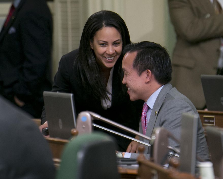 Assemblywoman Autumn Burke, D-Inglewood, talks with Assemblyman David Chiu, D-San Francisco, after their measure regulating pregnancy centers was approved by the Assembly in Sacramento, Calif., Tuesday May 26, 2015.The bill AB775 would require pregnancy centers to post notices saying that reproductive health services, including abortion, are available to pregnant women and may be financed under government programs. It would not require referrals to abortion clinics. The centers would also have to disclose if they are not medically licensed. The legislation now goes to the Senate. (AP Photo/Rich Pedroncelli)