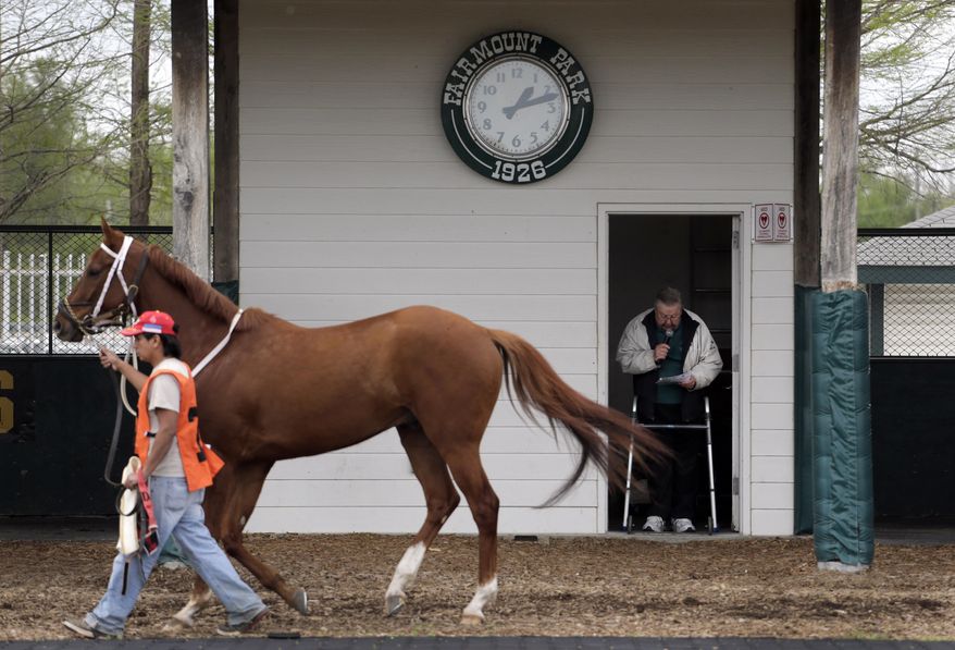 FILE - In this Tuesday, April 21, 2015, file photo, track handicapper Jay Randolph stands in a doorway with the aid of a walker and previews the field for an upcoming race for fans at Fairmount Park in Collinsville, Ill. The owners of an East St. Louis casino plan to purchase the struggling Fairmount Park racetrack, provided Illinois lawmakers agree to allow a gambling expansion that would bring slot machines to the state's five horse racing venues. Employee-owned CQ Holdings Inc., owner of the riverfront Casino Queen, announced a tentative agreement to buy the 90-year-old track located eight miles to the east in Collinsville Tuesday, May 26, 2015. (AP Photo/Jeff Roberson, File)
