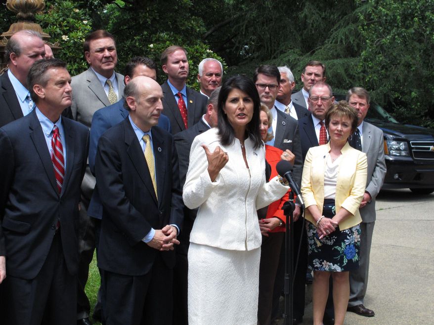 South Carolina Gov. Nikki Haley surrounds herself with Republican lawmakers as she talks about what she would like to do with $400 million in extra revenue the state is expected to get at a news conference on Tuesday, May 26, 2015, in Columbia, S.C. Haley said the Legislature needs to give a tax cut, pay off debt or fix the state's roads and bridges with the extra revenue. (AP Photo/Jeffrey Collins)