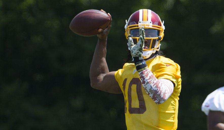 Washington Redskins quarterback Robert Griffin III throws a pass during an NFL football organized team activity at Redskins Park, on Tuesday, May 26, 2015, in Ashburn, Va. (AP Photo/Evan Vucci)
