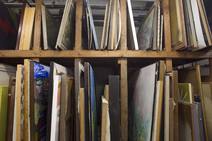 Art stacks up May 20, 2015, inside the University of Iowa Thesis Rental Gallery on the UI Research Park in Coralville, Iowa. The collection began in 1939, when graduating artists from the UI?s MFA program were required to leave their theses with the school. The requirement ended more than a decade ago but the gallery still receives donations. The art is available for rent to university employees and departments. (David Scrivner /Iowa City Press-Citizen via AP)