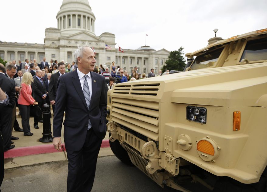 Arkansas Gov. Asa Hutchinson walks by a prototype of a tactical vehicle that will replace the Humvee, parked in front of the Arkansas state Capitol in Little Rock, Ark., Tuesday, May 26, 2015. Hutchinson called the defense project he hopes to lure with an $87 million incentive package being considered by lawmakers this week a golden opportunity for the state. (AP Photo/Danny Johnston)