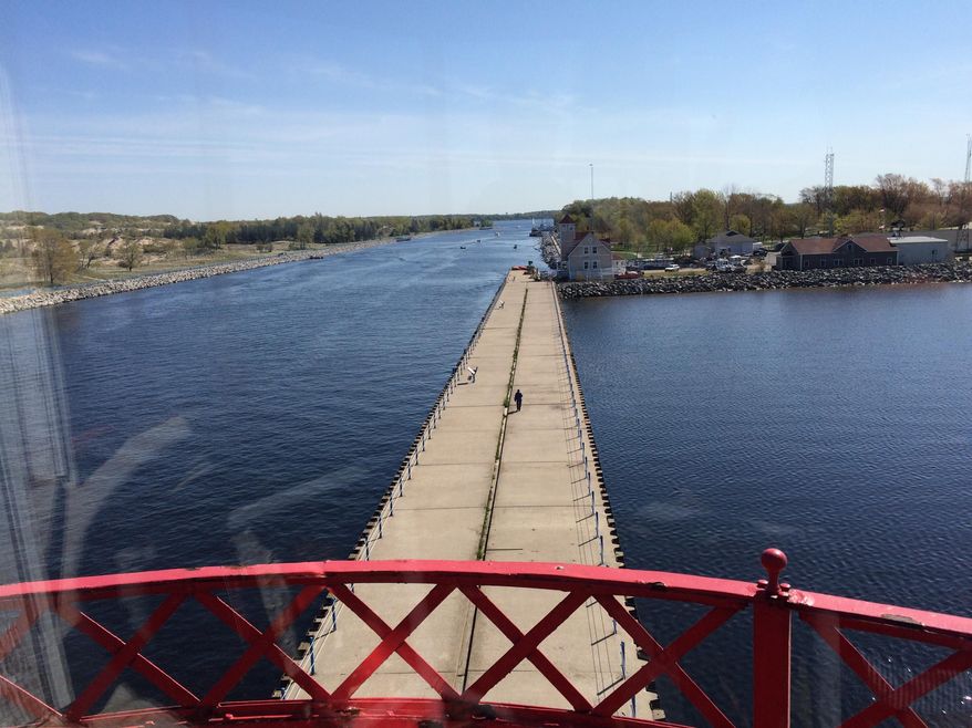 In this Saturday, May 23, 2015 photo, the Michigan Lighthouse Conservancy holds a small ceremony and ribbon cutting to celebrate the beginning of public tours of Muskegon's South Pierhead Lighthouse in Muskegon, Mich. Many guests took the opportunity to climb to the top of the historic, 48-foot tall structure. (Brandon Champion/The Muskegon Chronicle via AP) ALL LOCAL TELEVISION OUT; LOCAL TELEVISION INTERNET OUT