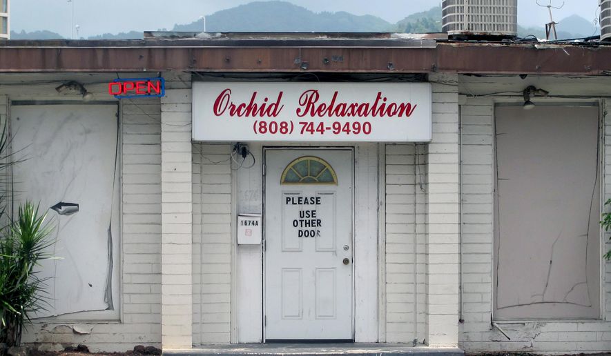 FILE - This May 6, 2015 file photo shows an open sign hanging outside Orchid Relaxation in Honolulu. The massage parlor was one of several local businesses that were targeted in a police prostitution sting. Honolulu’s top prosecutor is dismissing sex assault charges against 16 women arrested in the massage parlor prostitution sting. Prosecuting Attorney Keith Kaneshiro said Wednesday, May 27, the allegations might have constituted a technical violation of law, but proof beyond a reasonable doubt couldn’t be established. (AP Photo/Jennifer Sinco Kelleher,File)