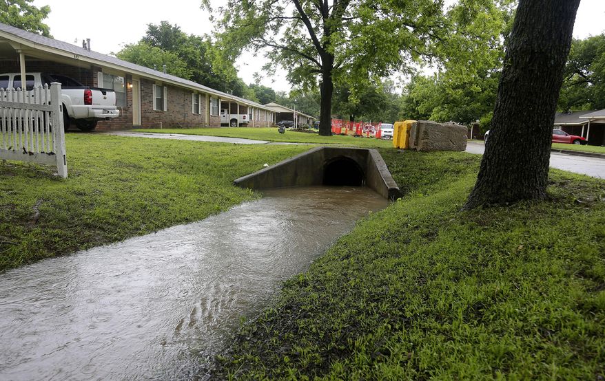 In this May 25, 2015 photo is the box culvert where Claremore Fire Department Capt. Jason Farley was trapped and drowned on Saturday in Tulsa, Okla. Farley and another firefighter who tried to rescue him were pulled into the drain pipe. The other firefighter traveled 200 yards until he was ejected from the pipe and survived the near-drowning, but Farley got caught inside and died. His drowning highlights the persistent dangers posed by storm drains that help protect neighborhoods during flash flooding but can suck in unsuspecting residents and emergency workers. (Mike Simons/Tulsa World via AP) KOTV OUT; KJRH OUT; KTUL OUT; KOKI OUT; KQCW OUT; KDOR OUT; TULSA OUT; TULSA ONLINE OUT